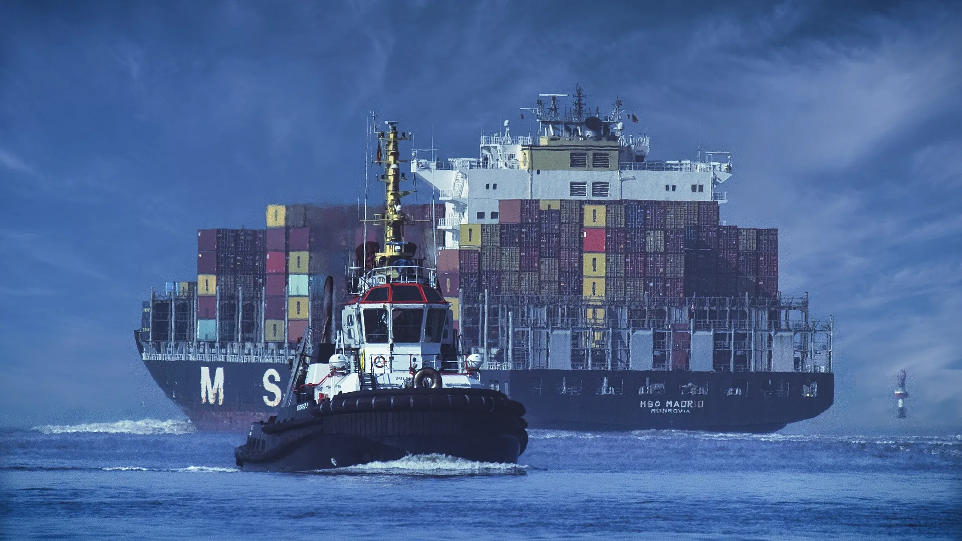 Blick auf ein Losten- und ein Containerschiff